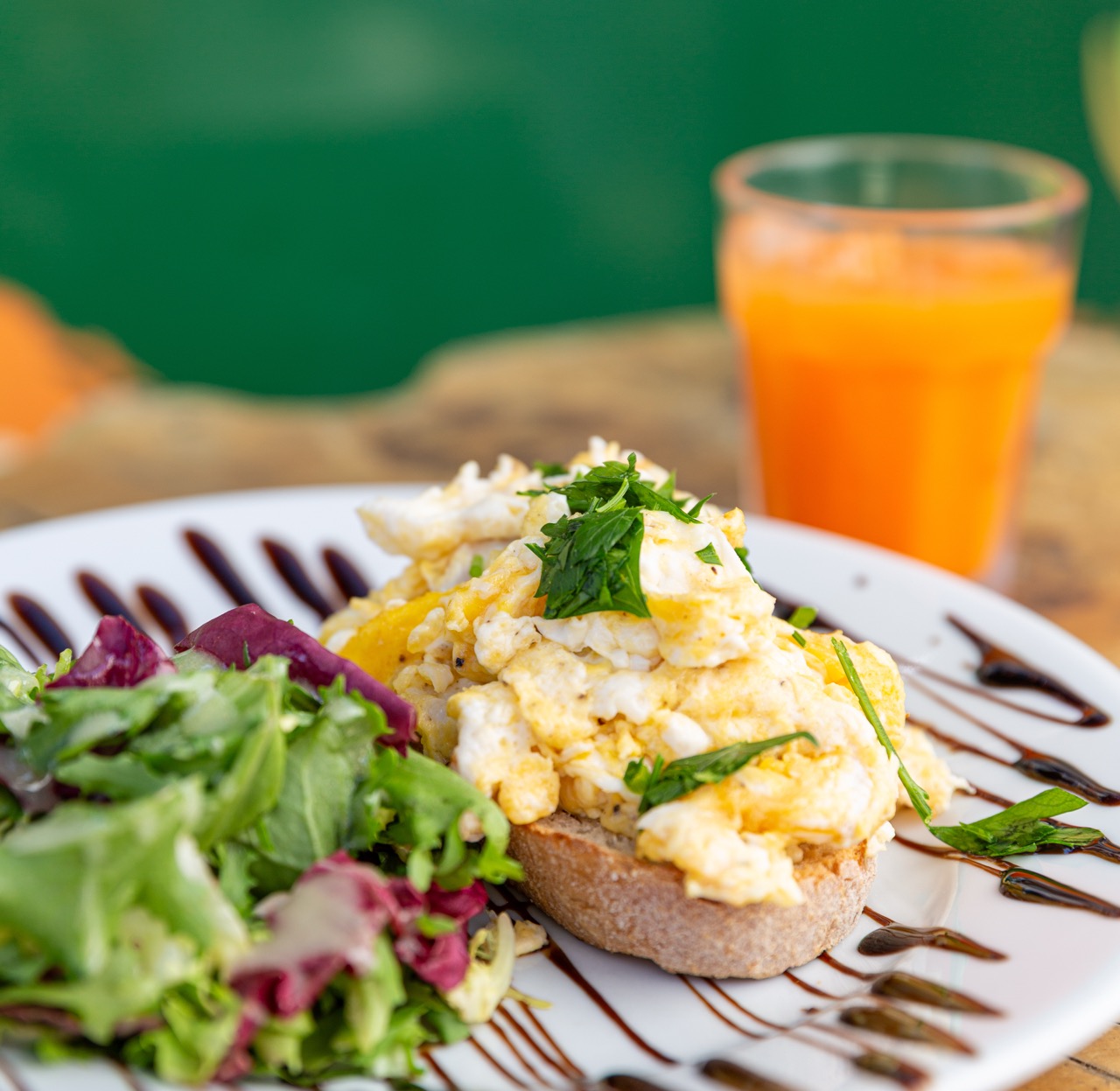 Creamy scrambled eggs on artisanal toast with fresh herbs
