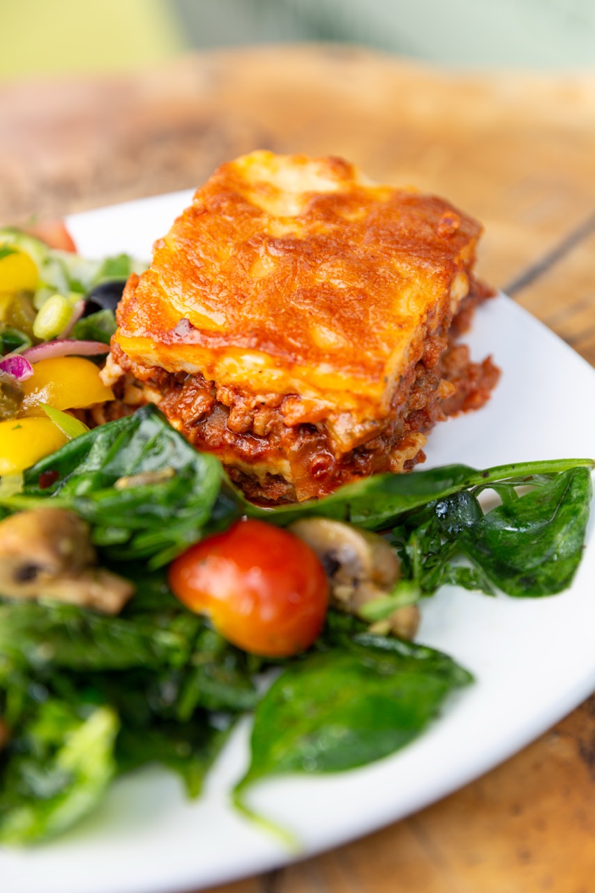 Golden vegan moussaka with fresh mixed greens